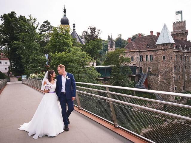 Brautpaar am Steg mit Schloss Rothschild im Hintergrund