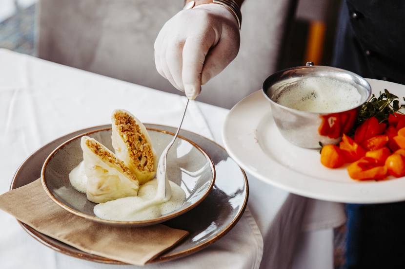 Krautrouladen vegetarisch beim Anrichten mit Kräuterschaum